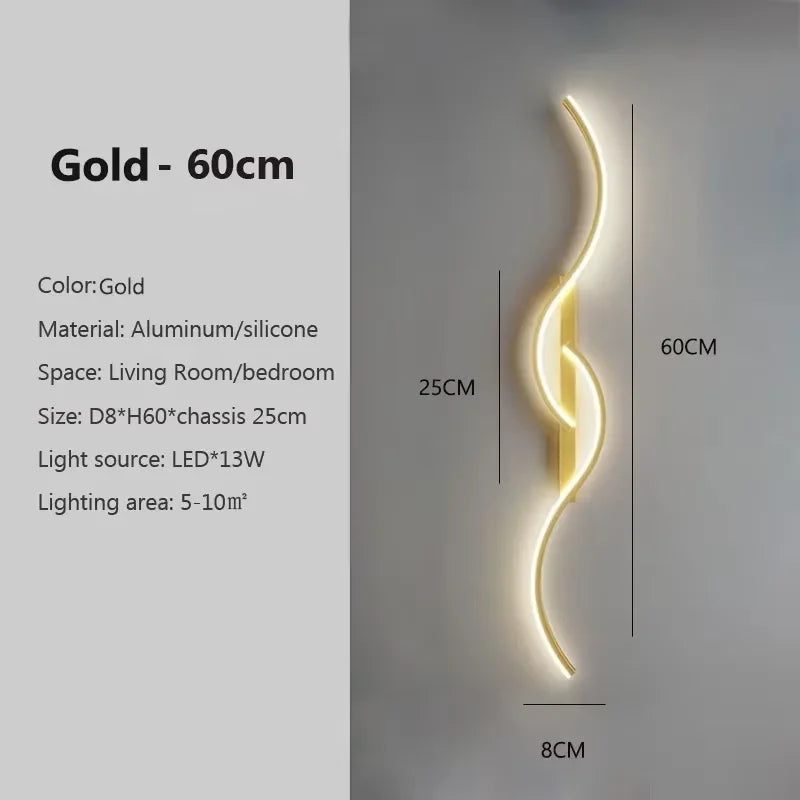 A vertical gold LED wall lamp with a curved design mounted on a light gray wall.