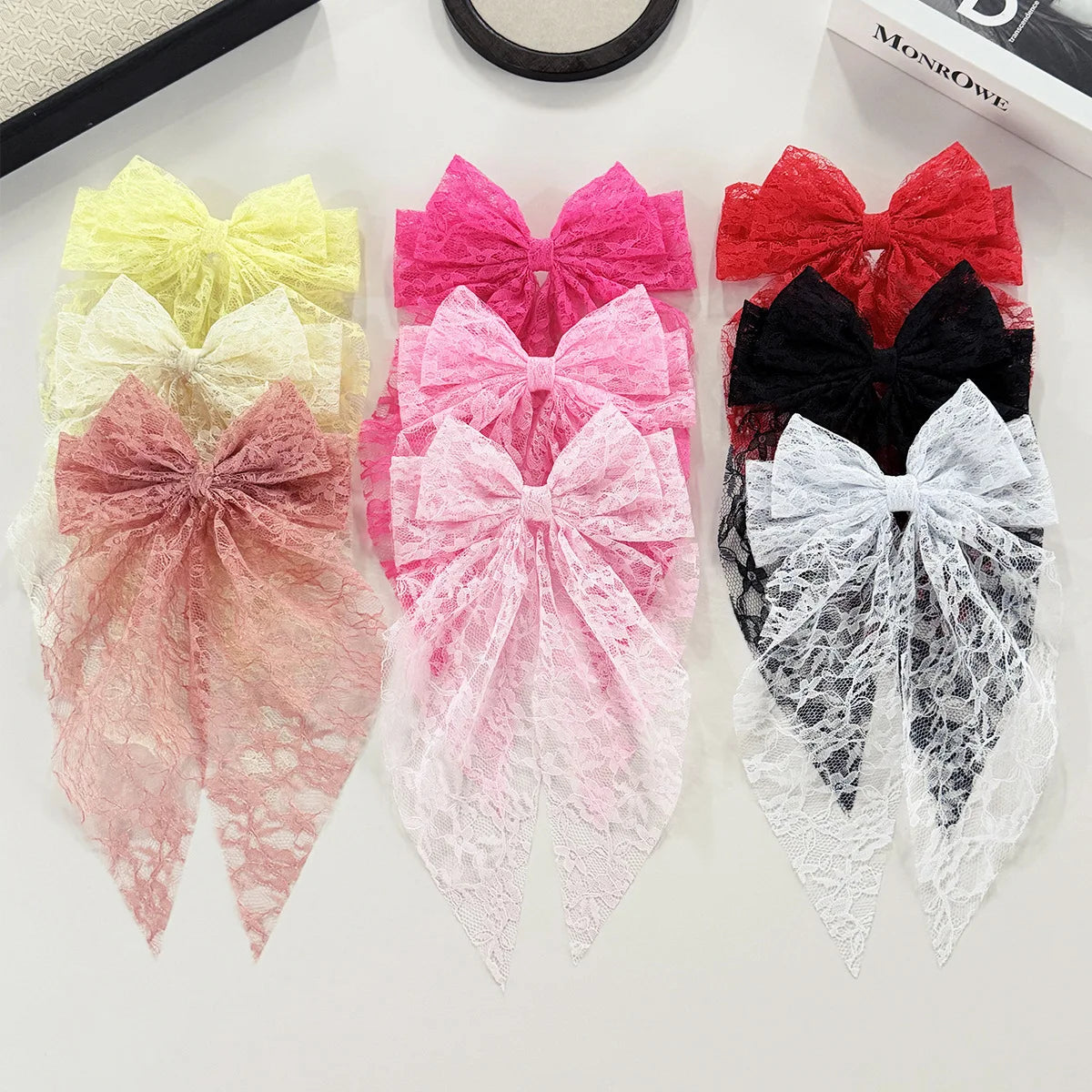 A collection of pink, red, and white lace bow hair clips for women in various styles.