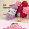 Purple milk colored yarn skein with a label for skin-friendly use surrounded by various pink and red yarn balls.