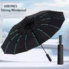 A black 60-bones strong windproof umbrella is shown open against a bright sky and white surface.