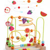 A wooden bead maze toy showing various fruits and vegetables arranged on a wooden track.