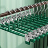 A set of five anti-slip stainless steel hangers with clips for pants and skirts, displayed in a green and wood tone.