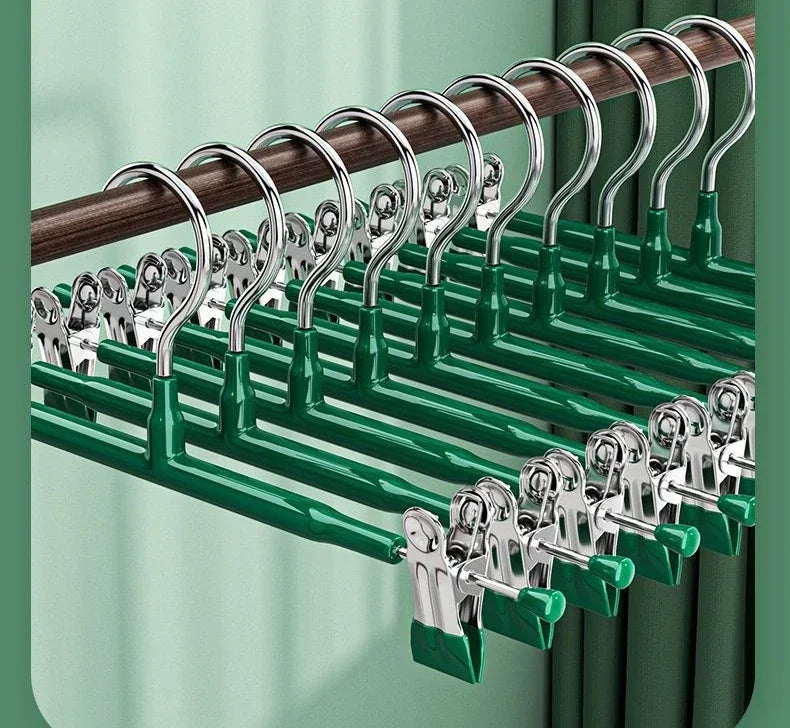A set of five anti-slip stainless steel hangers with clips for pants and skirts, displayed in a green and wood tone.
