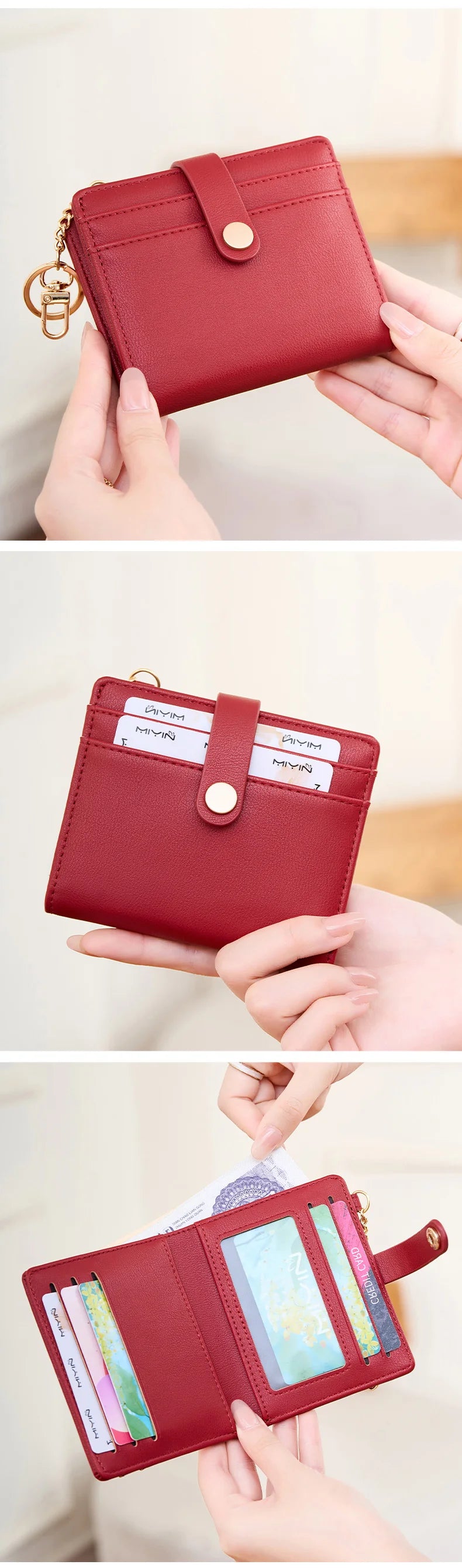 A close-up of a red leather bi-fold credit card wallet with a gold chain and a wooden background.