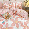 Pink floral bedding set featuring a duvet cover and pillows with a white background.