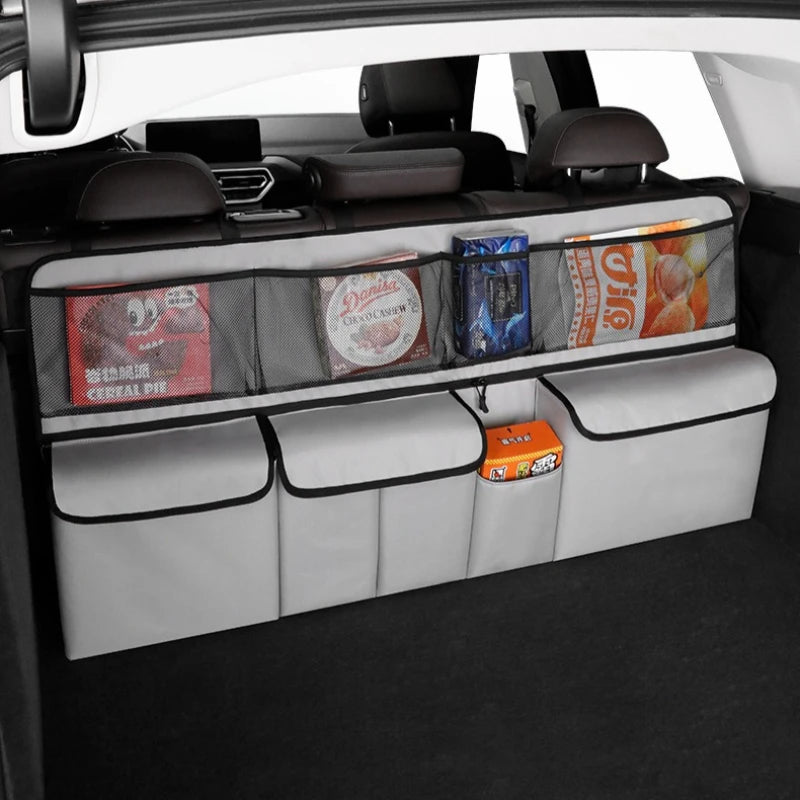 Foldable car trunk organizer with seat back storage showing various items stored in the compartment.