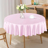 A round table set with a pink satin tablecloth, a glass vase of flowers, and a white cup and saucer.
