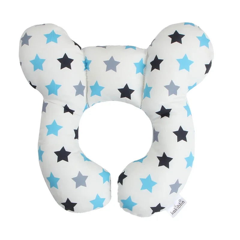 A white baby head and neck support pillow with blue stars and black stars.