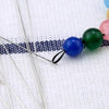 Stainless steel beading needles with colorful beads on a white background