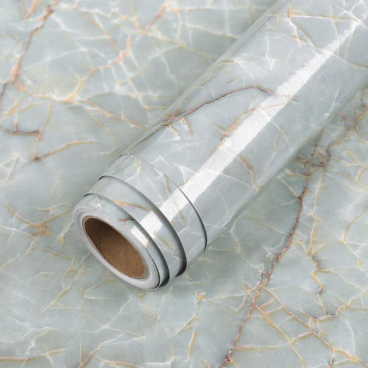 Roll of waterproof self-adhesive marble wallpaper featuring gray and beige veining on a light background.