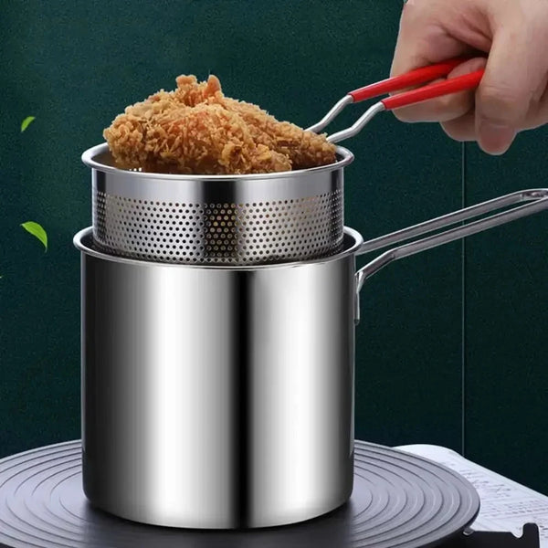 Eine Hand benutzt Zangen, um ein goldbraunes, frittiertes Stück aus einem Edelstahl-Frittiertopf zu heben.