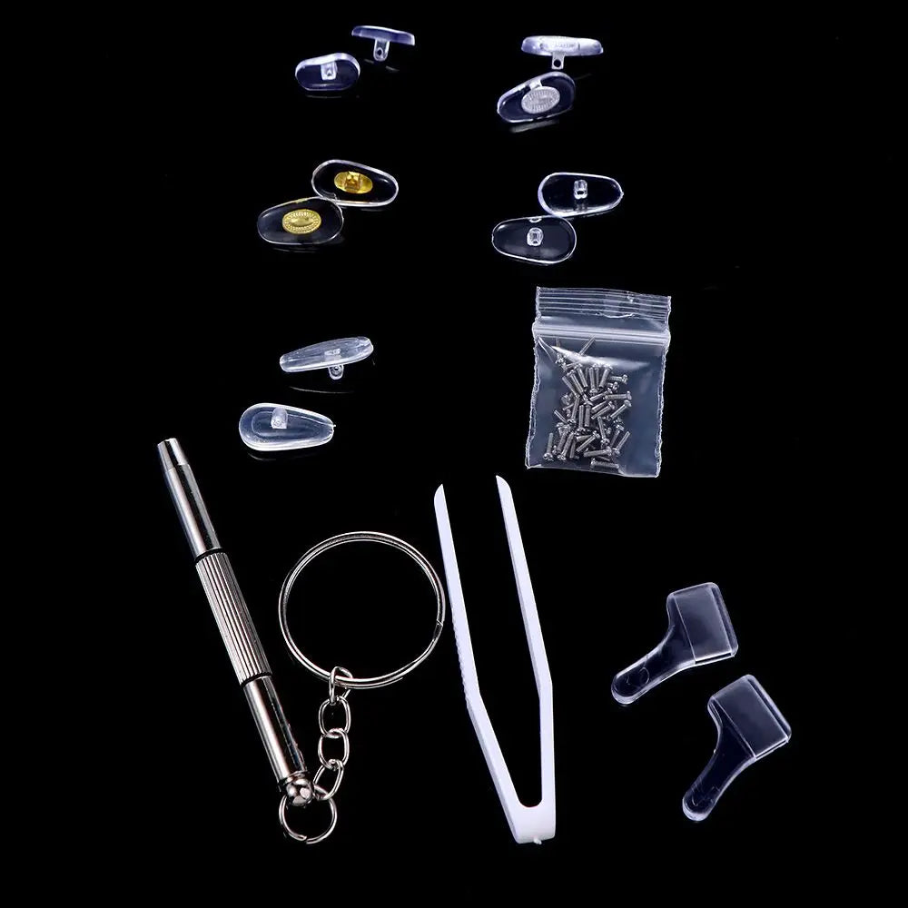 A collection of complete glasses repair kit components including nose pads, screws, and precision tools displayed against a b