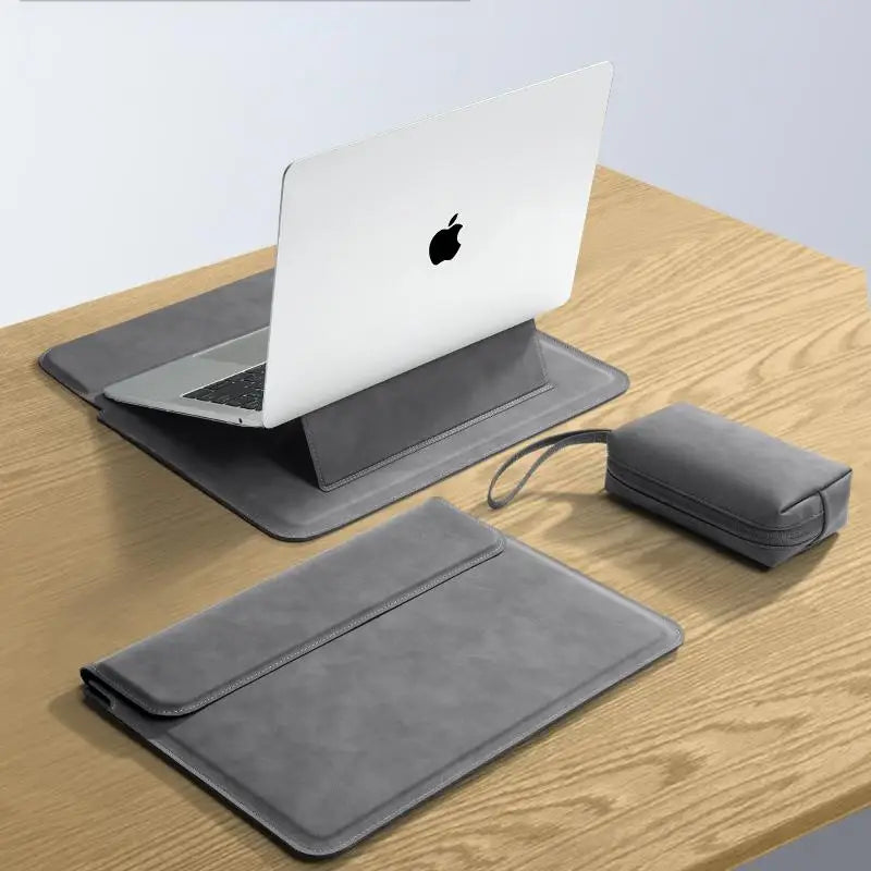 A silver laptop is placed on a gray protective sleeve case on a wooden surface.