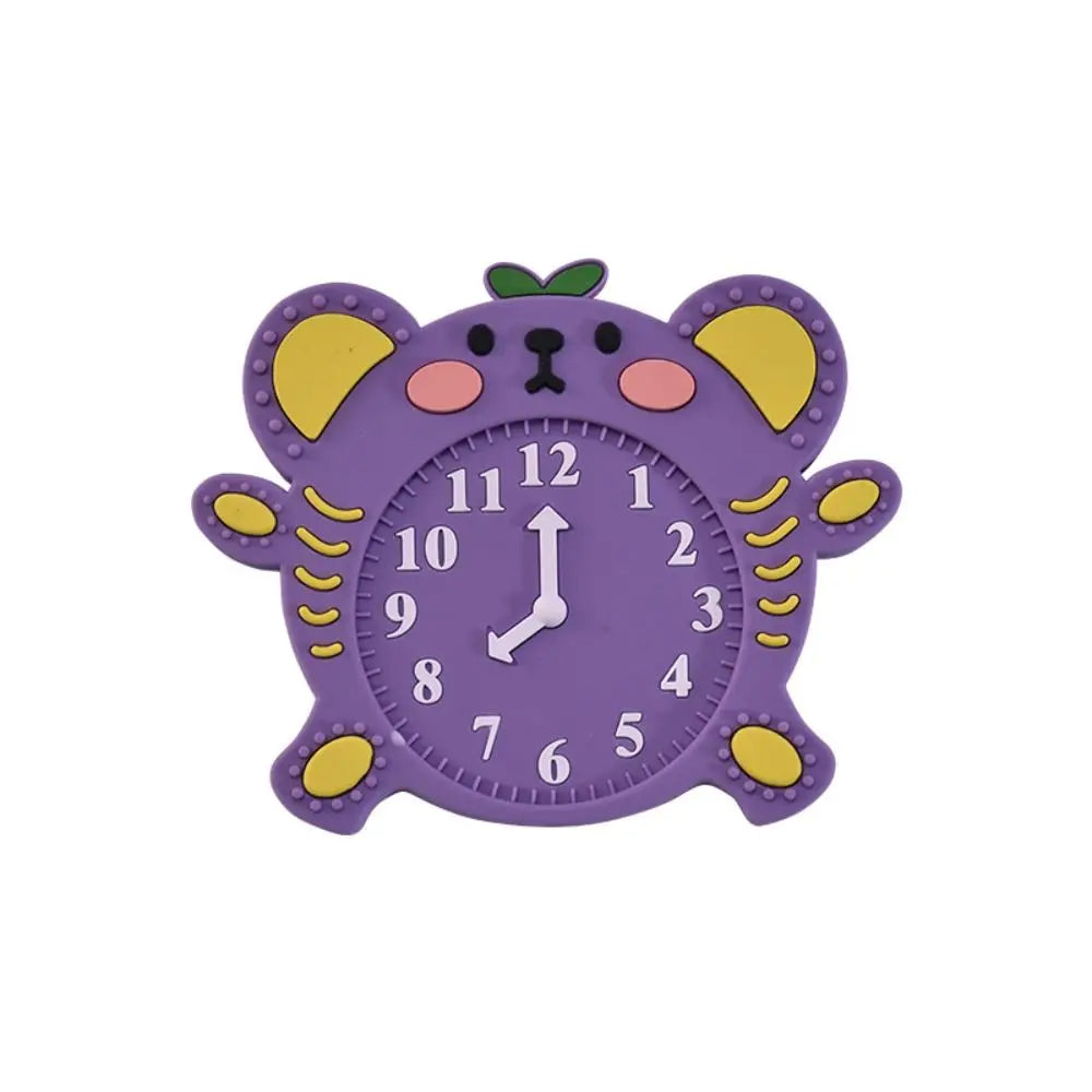 A purple silicone teether toy shaped like a cat with yellow ears and a green nose.