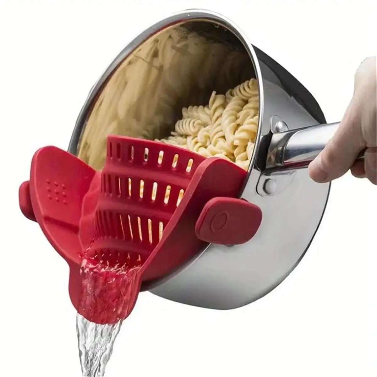 A hand is pouring red liquid from a red strainer into a metal pot, which contains dry pasta.