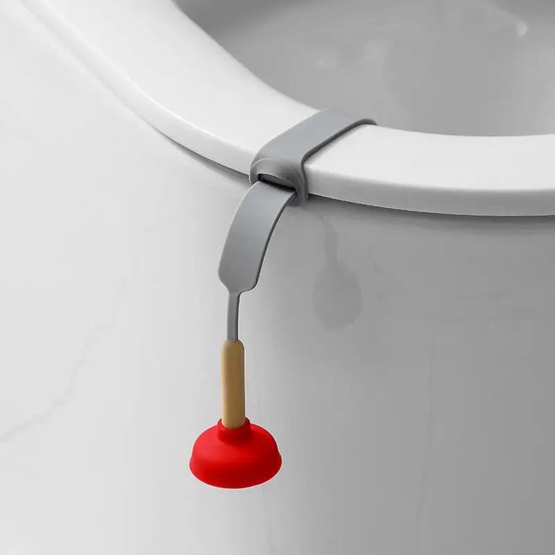 A silver and wooden hands-free toilet lid lifter attached to a white ceramic toilet rim.