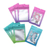 A collection of gradient colored resealable zipper pouches with clear windows in pink, purple, and teal.