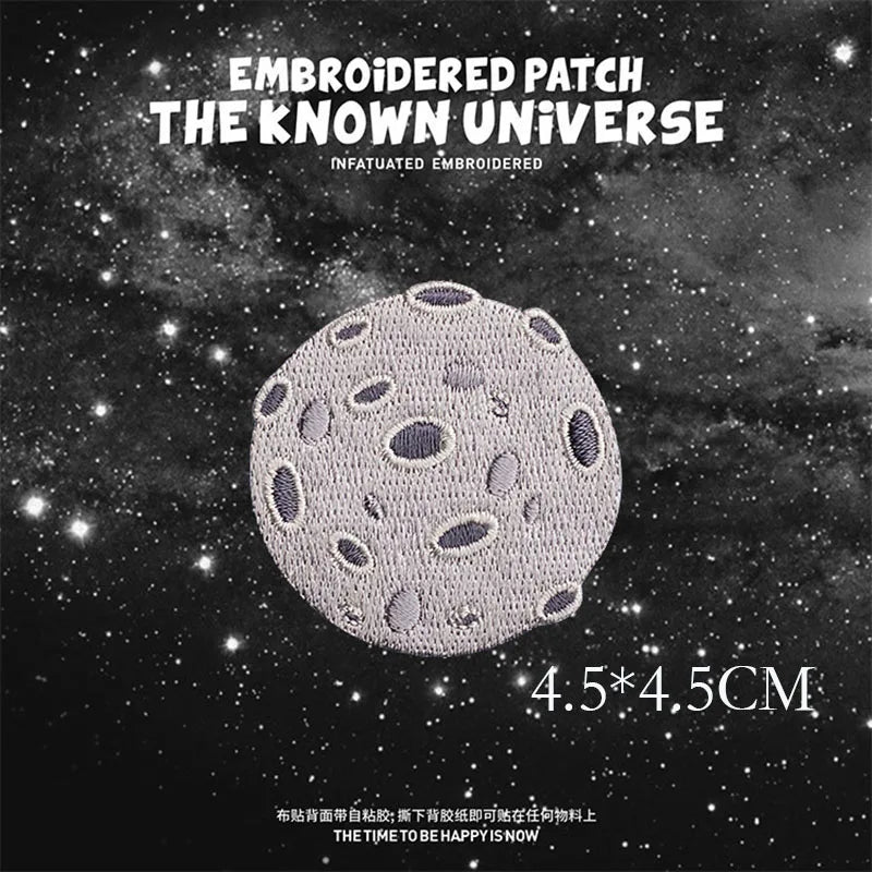 Embroidered patch design featuring a textured, gray celestial body against a dark starry background.