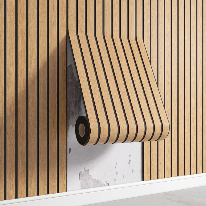 Roll of wood-grain self-adhesive wall panels mounted on a white shelf against a vertical wooden slat background