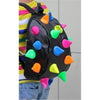 A black backpack adorned with colorful, shiny, pom-pom-like embellishments.