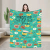 A teal throw blanket featuring a pattern of coffee cups, pastries, and the text "FIRST I DRINK THE COFFEE THEN I DO THE THING
