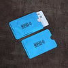 A blue RFID protection card sleeve is shown next to a white card on a dark surface.