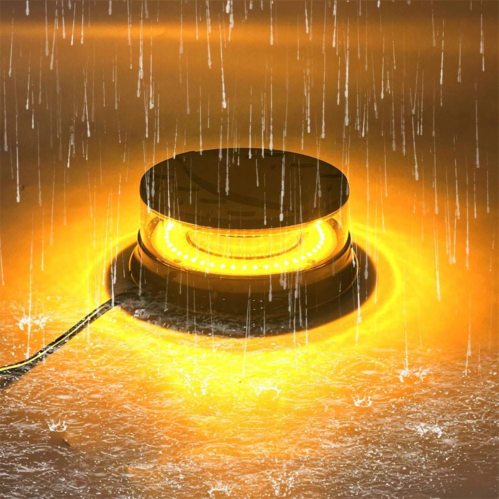 An LED emergency strobe light mounted on a magnetic base, emitting a bright yellow glow amidst falling rain.