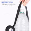 A hand is pulling a black cloth tape from a plastic bottle, demonstrating super sticky adhesive.