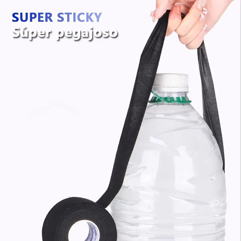 A hand is pulling a black cloth tape from a plastic bottle, demonstrating super sticky adhesive.