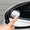 A hand is adjusting a car blind spot mirror with rain shields to check its functionality.