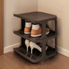A dark gray stackable vertical shoe rack with three tiers holding various pairs of shoes.