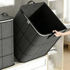 A black foldable storage organizer bag is shown open, displaying its interior, next to a glass shelf.