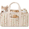 A beige floral diaper organizer bag with multiple compartments filled with baby items.