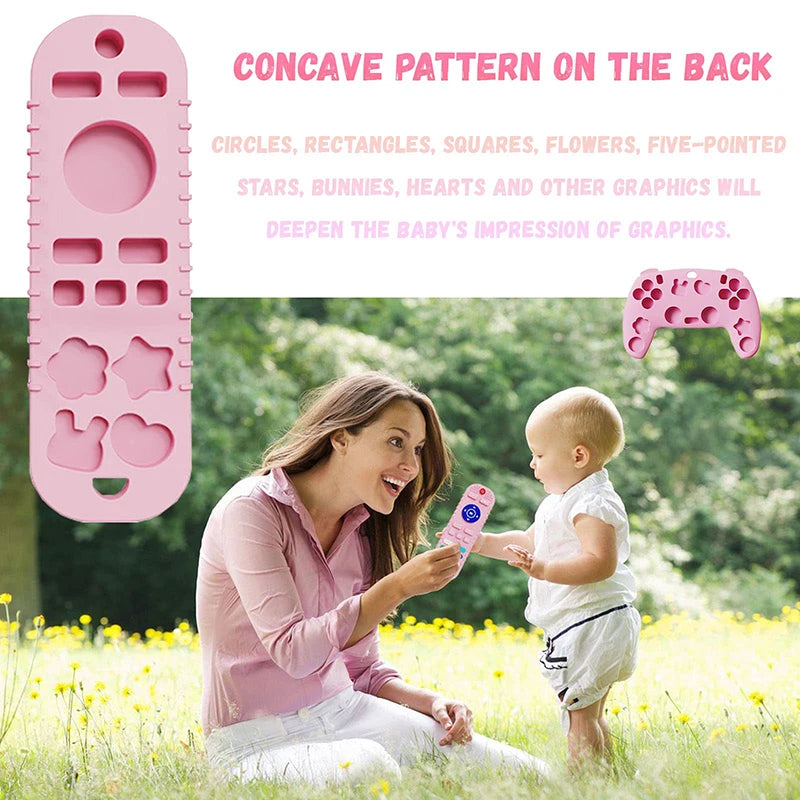 A woman is showing a silicone baby teether remote control toy to a baby outdoors in a sunny field.