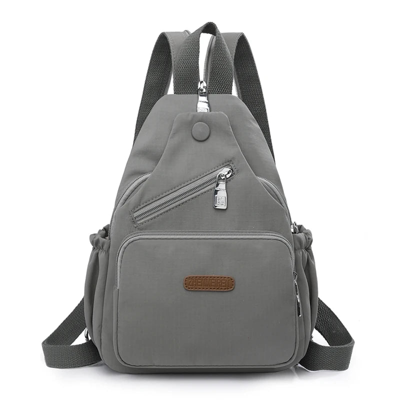 A gray waterproof nylon crossbody sling bag with adjustable straps and a zippered pocket.
