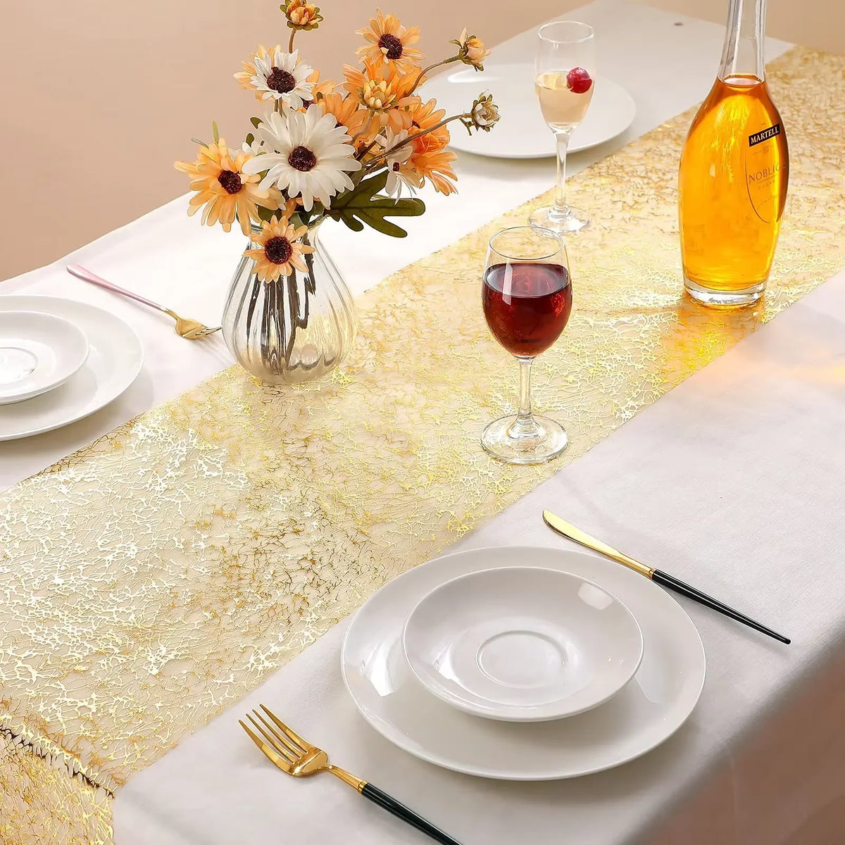 Metallic gold glitter table runner set with wine glass, fruit, and silverware for a wedding or party setting.