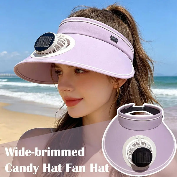 A woman wearing a wide-brimmed candy hat fan hat with a solar panel and adjustable fan on a sunny beach.