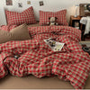 A red plaid duvet cover set with a matching quilt and pillows displayed on a bed.