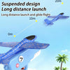 A blue foam catapult airplane toy is shown in flight against a light blue sky, demonstrating a long distance launch.