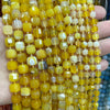 A close-up of yellow and amber natural stone square faceted beads strung together for jewelry making.