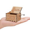 A hand-cranked wooden music box plays "Can't Help Falling in Love" featuring a silhouette of a couple.