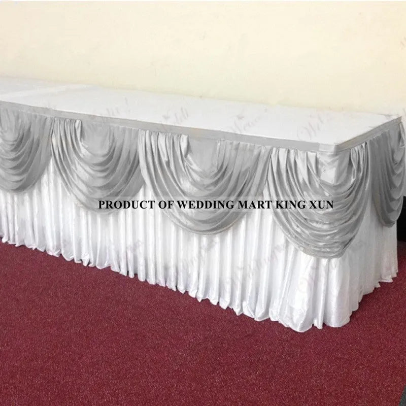 Elegant ice silk table skirt with matching top swag displayed on a white table.