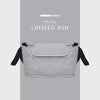 A gray flax linen organizer bag for a stroller, featuring a cup holder.
