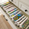 A set of eight transparent mesh zipper pouches in various sizes displayed in a white cabinet drawer.