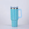 A bright blue rhinestone tumbler with a clear lid and straw, featuring a handle.
