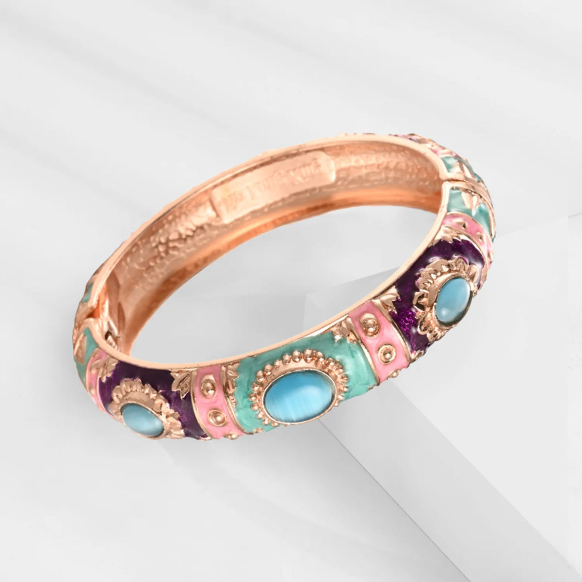 Rose gold plated bangle bracelet featuring colorful enamel work with pink, purple, and turquoise accents