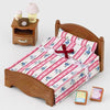A wooden bed frame with a striped pink and white bedding set and a small lamp accessory.