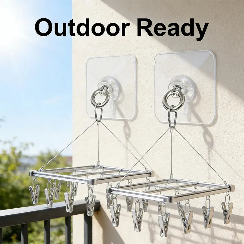 Outdoor ready stainless steel wall hooks with hangers mounted on a light-colored wall.