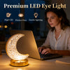 A woman works on a laptop illuminated by a crystal star moon night light.