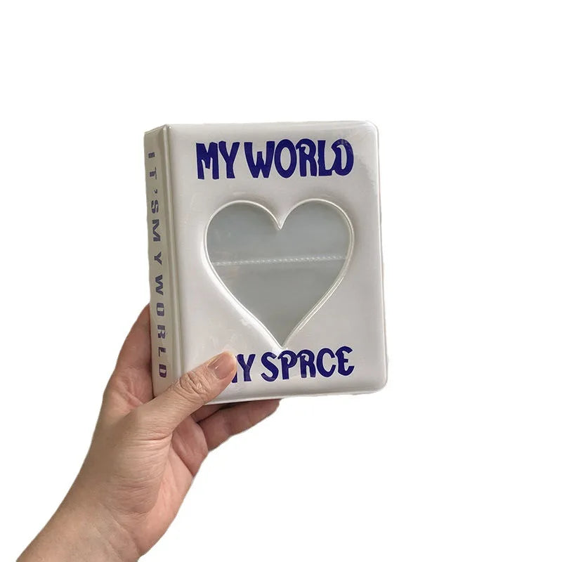A white mini photo album titled My World with a heart-shaped clear window.